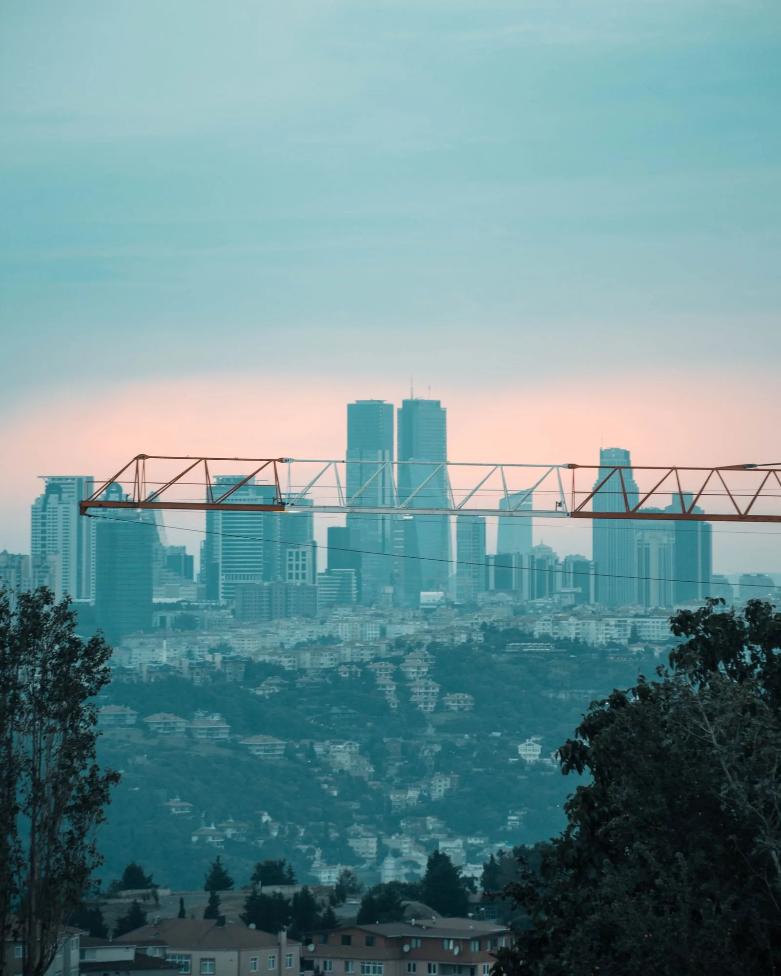 Construction crane against a finished city skyline